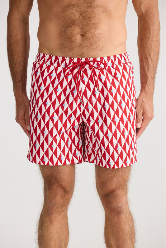 Red and white diamond patterned swim shorts on a plain background