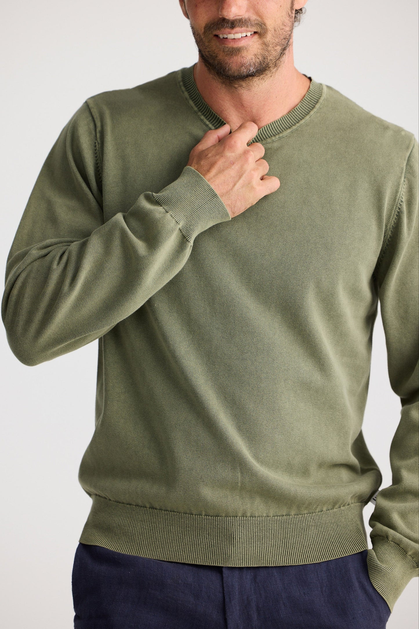 Man wearing a green sweater against a white background