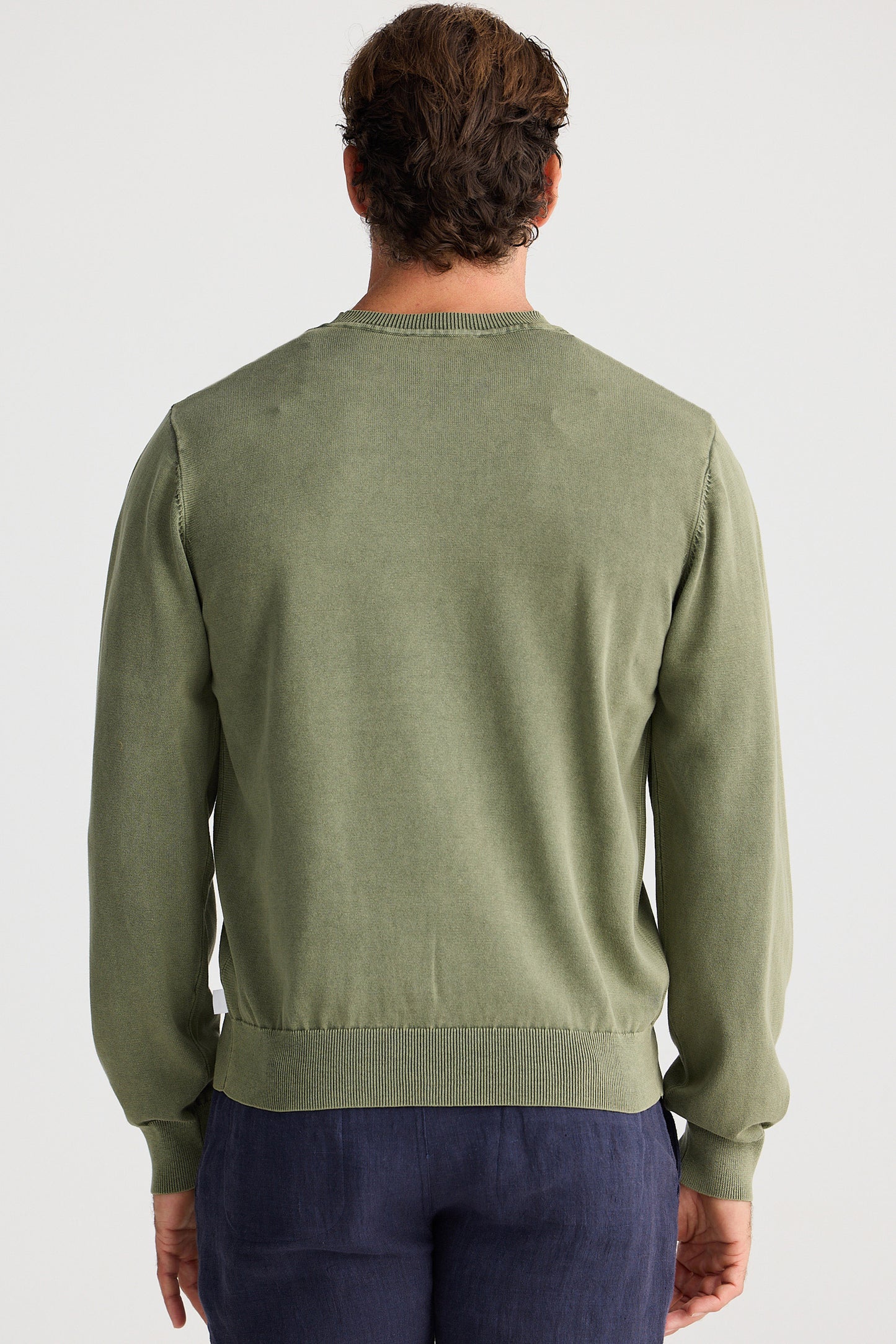 Person wearing a green sweater on a white background