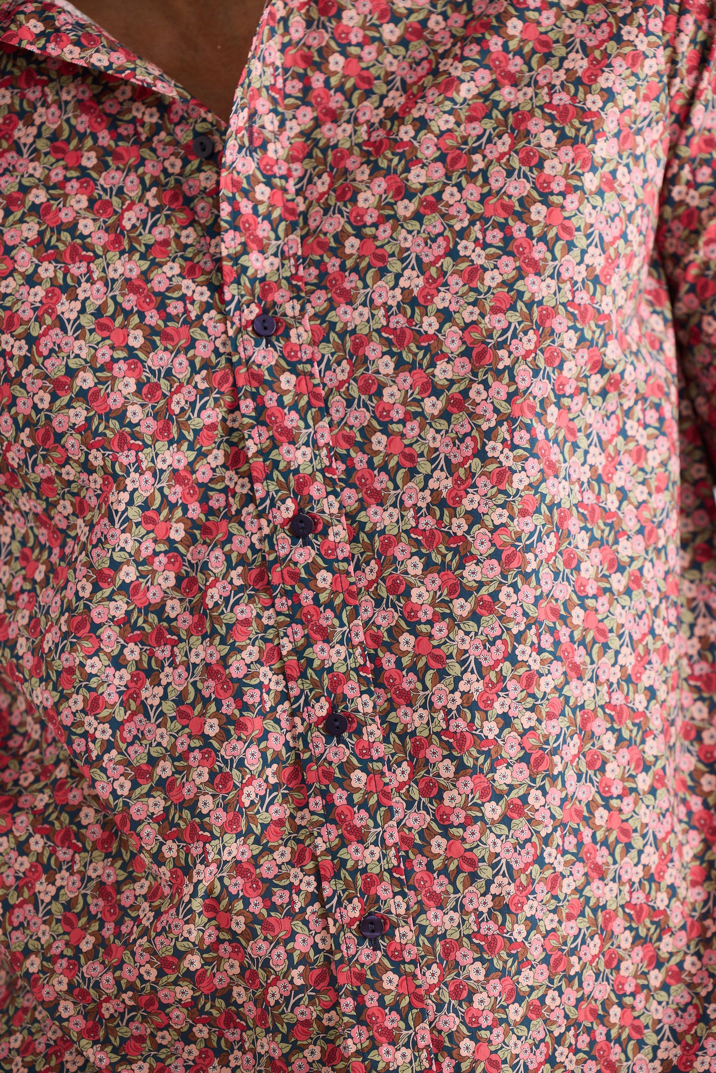 Close-up of a floral patterned fabric with pink and green colors.