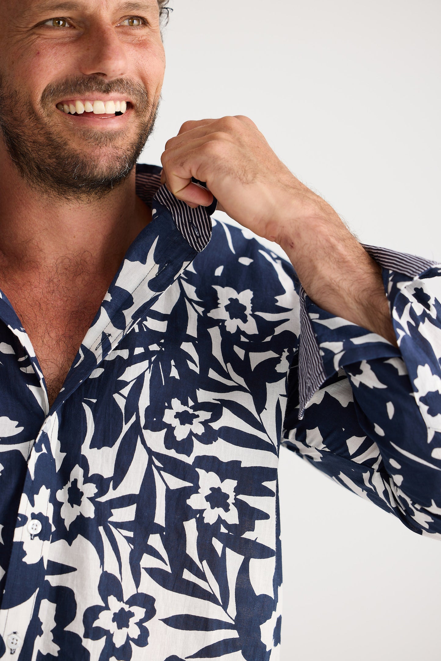 Man wearing a navy and white floral patterned shirt against a white background