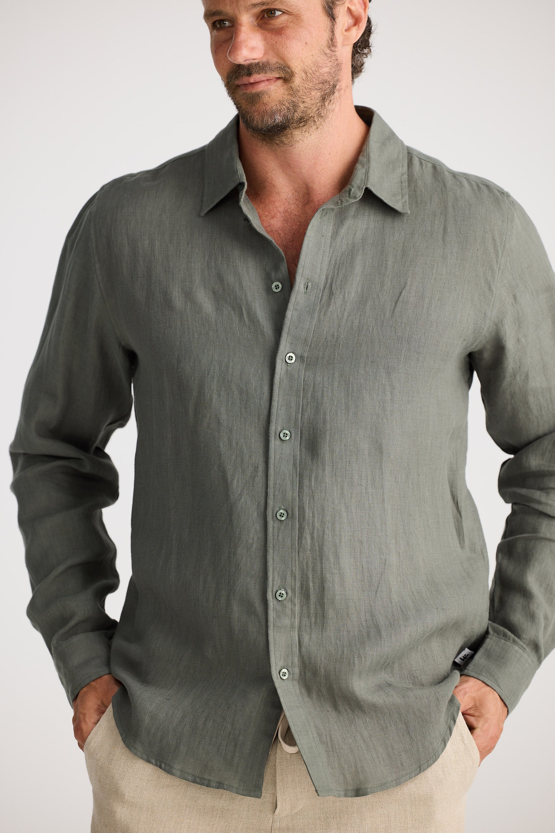 Man wearing a gray button-up shirt against a white background