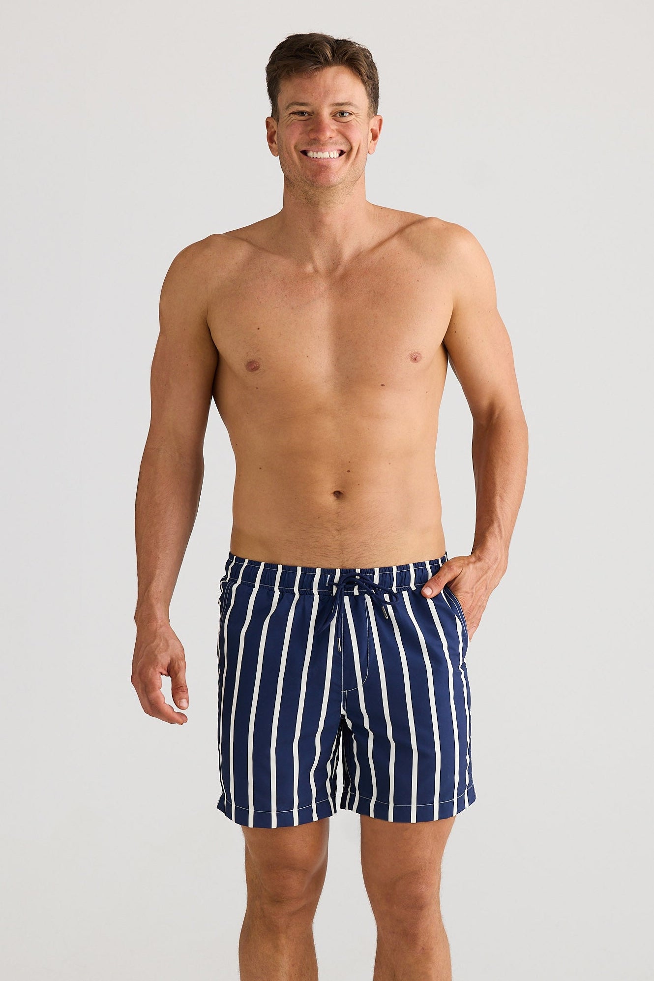 Man wearing navy striped swim shorts on a white background
