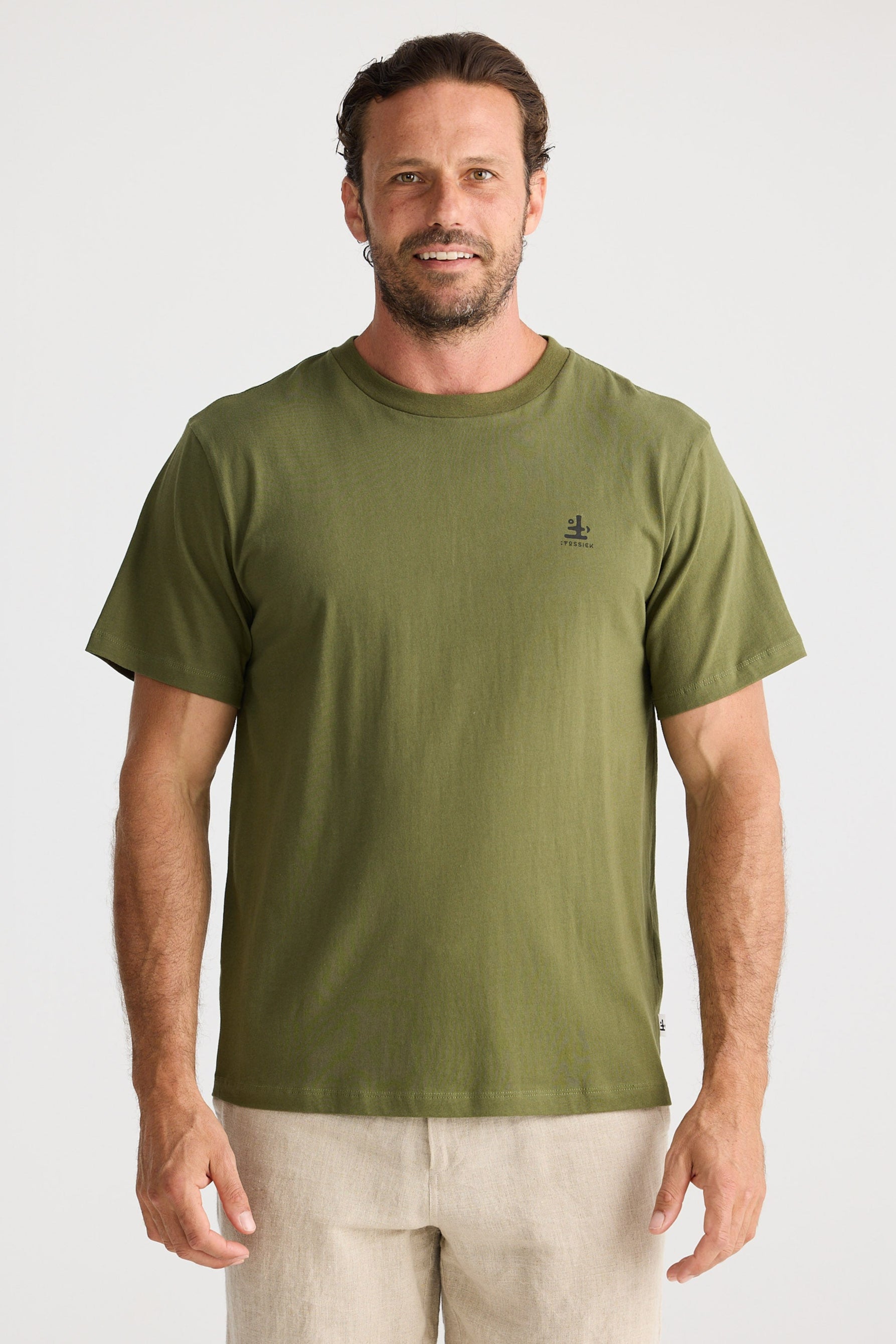 Man wearing an olive green t-shirt and beige shorts on a white background