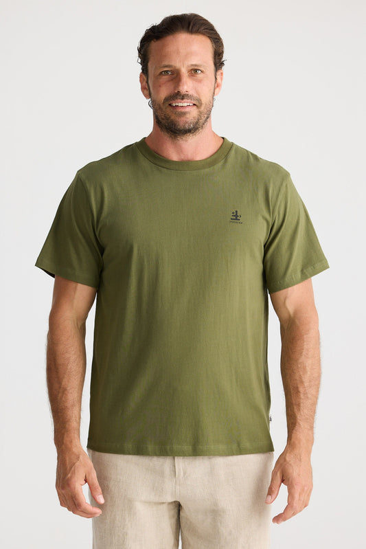 Man wearing an olive green t-shirt and beige shorts on a white background