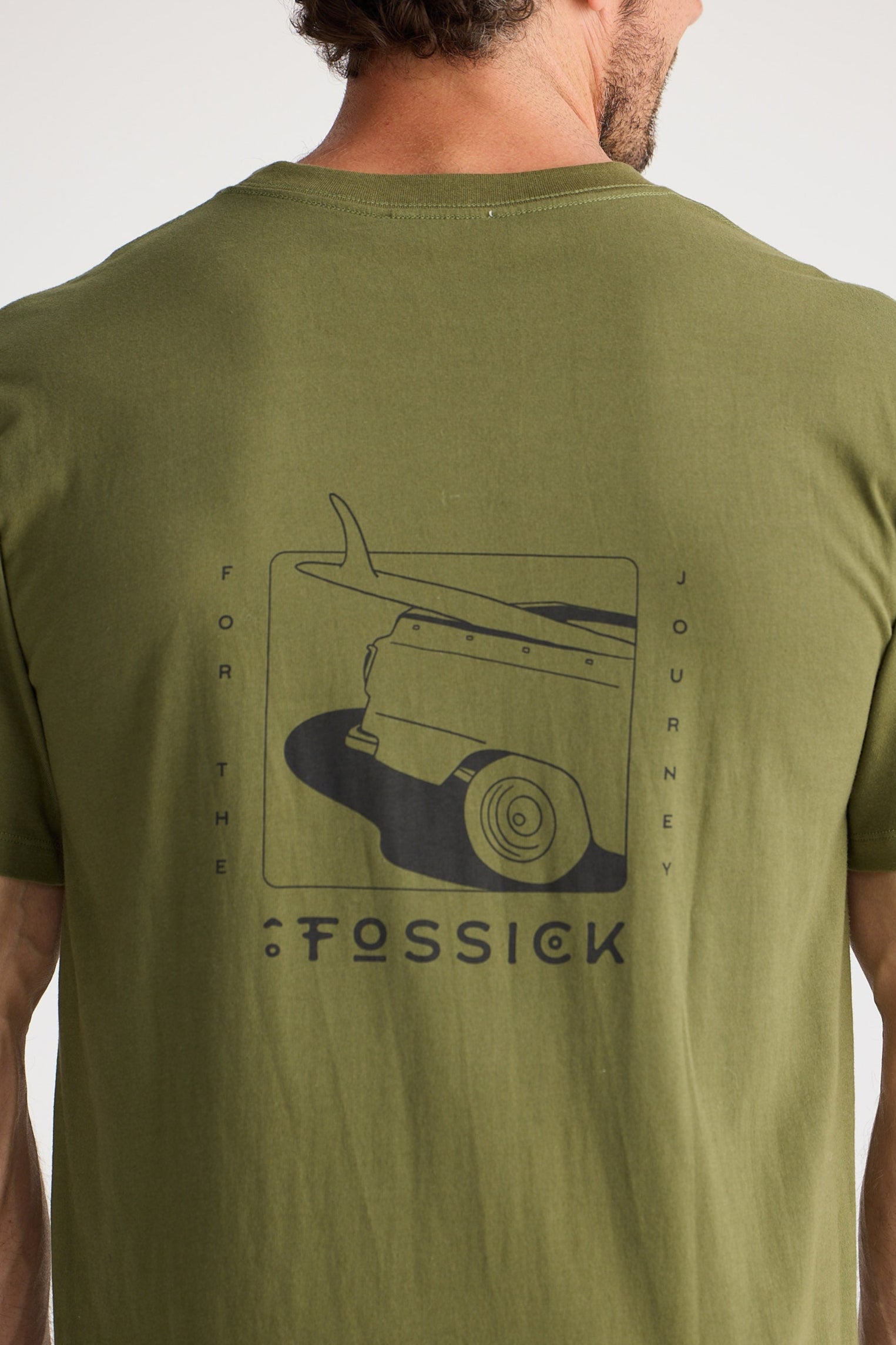 Person wearing a green t-shirt with a graphic design on the back, standing against a plain background.