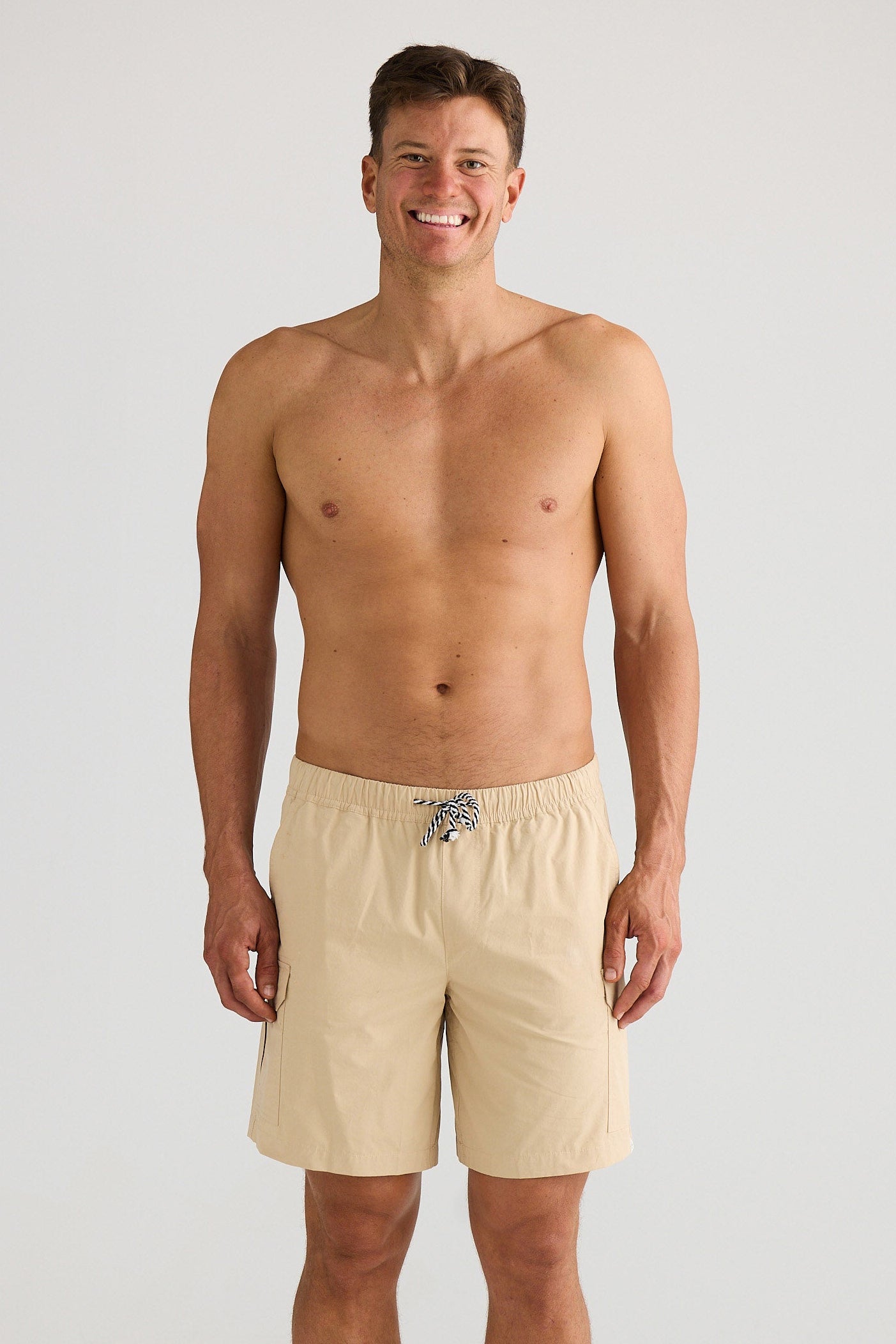 Man wearing beige shorts on a white background