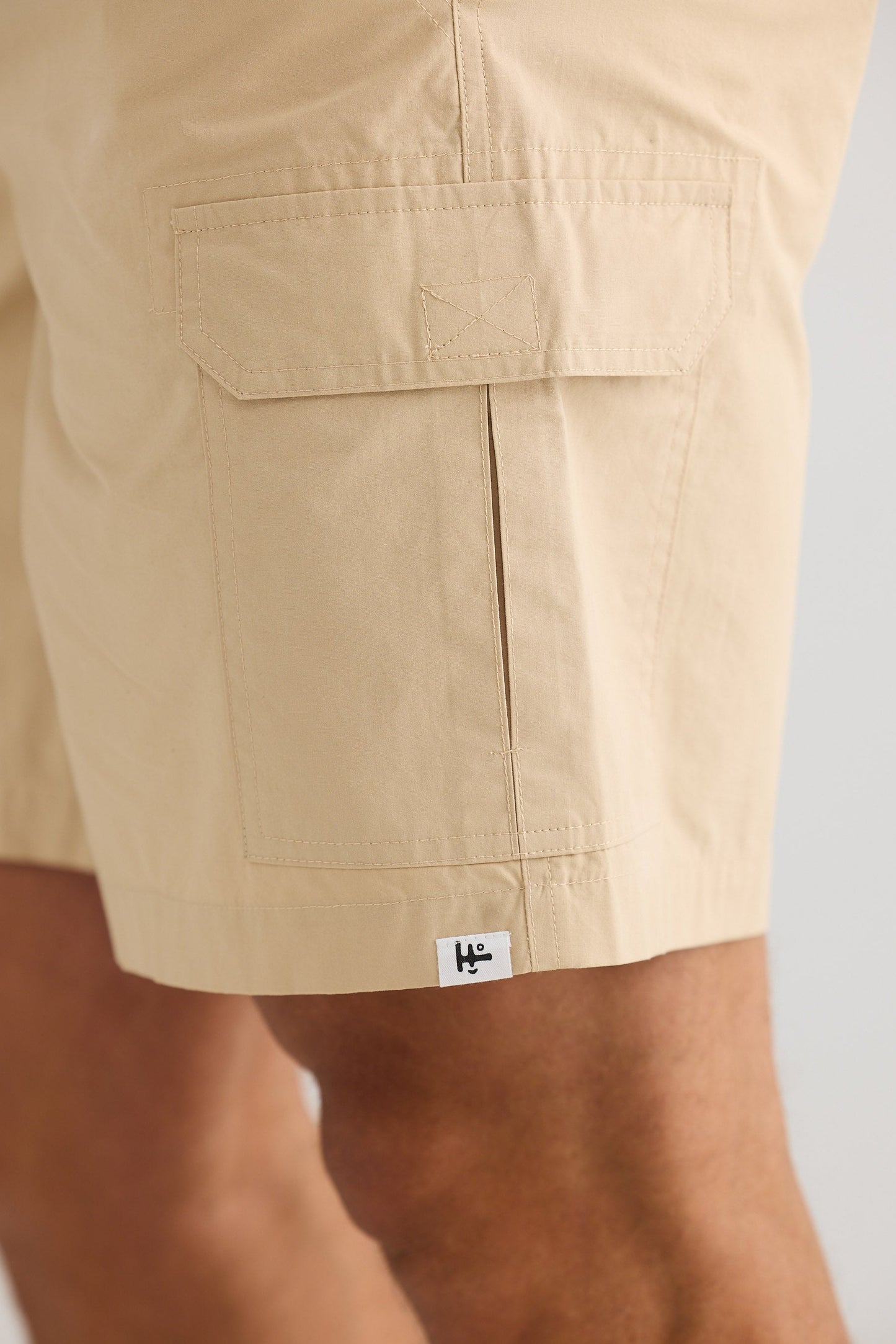 Beige shorts with a brand label on a neutral background