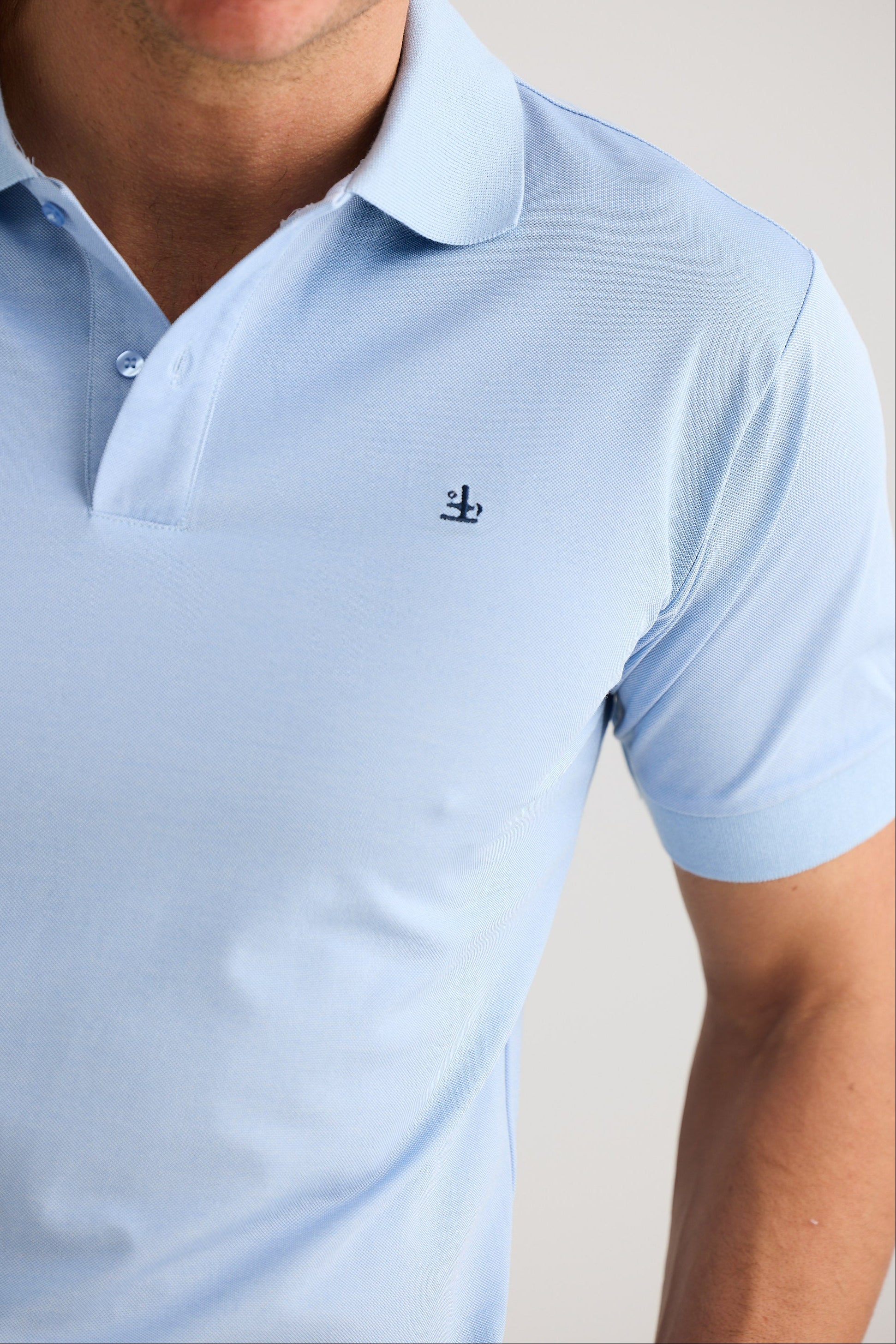 Light blue polo shirt with a small logo on a plain background