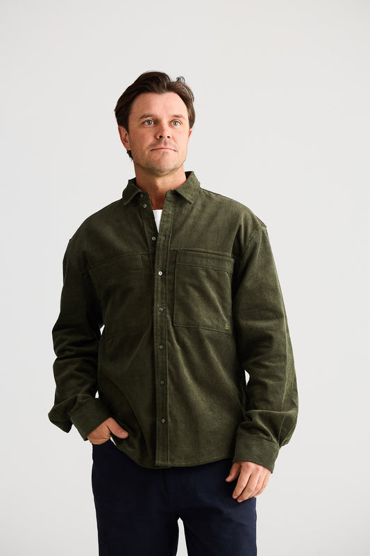 Man wearing a green shirt with a plain background