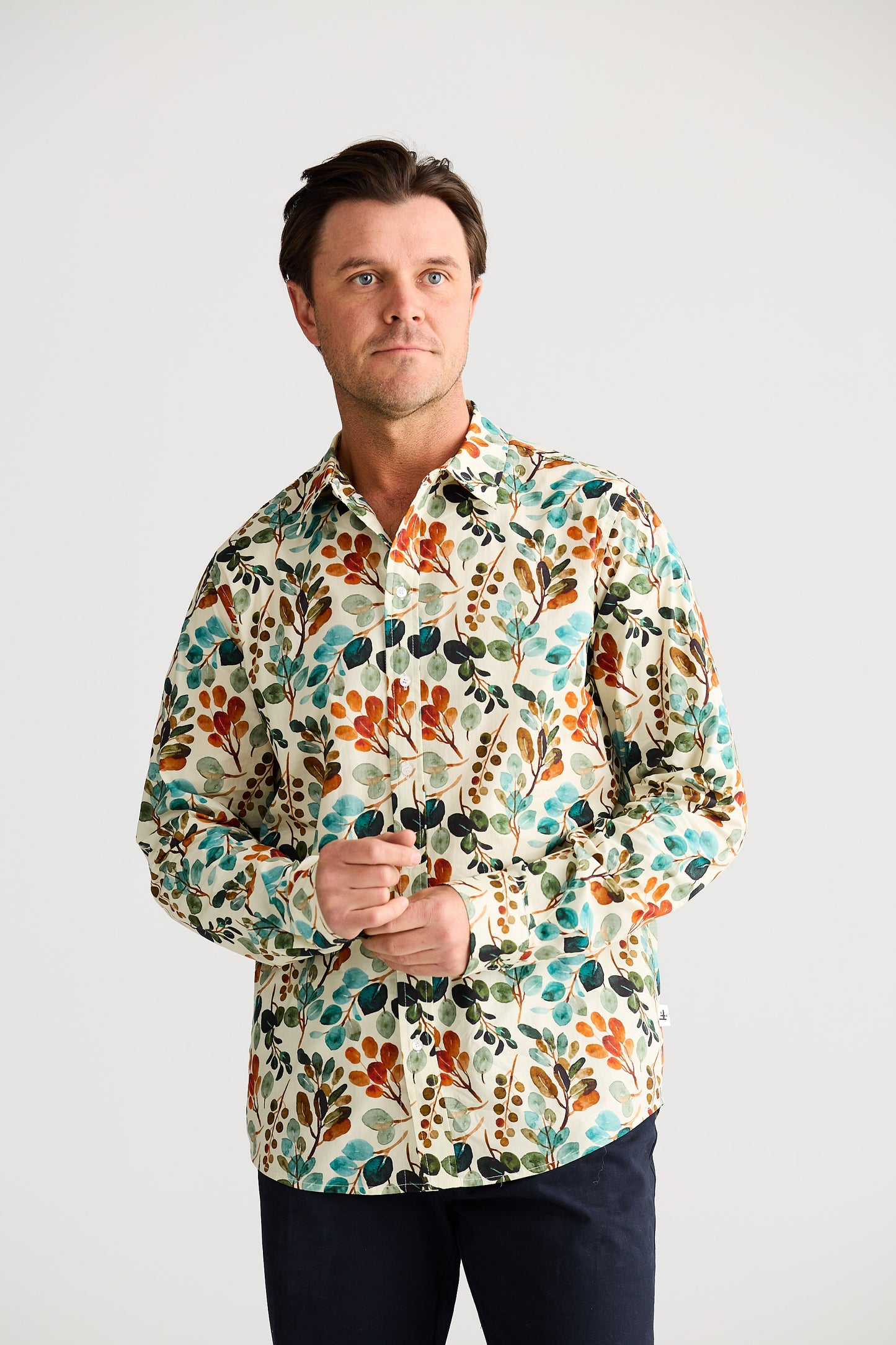 Man wearing a colorful floral shirt against a white background