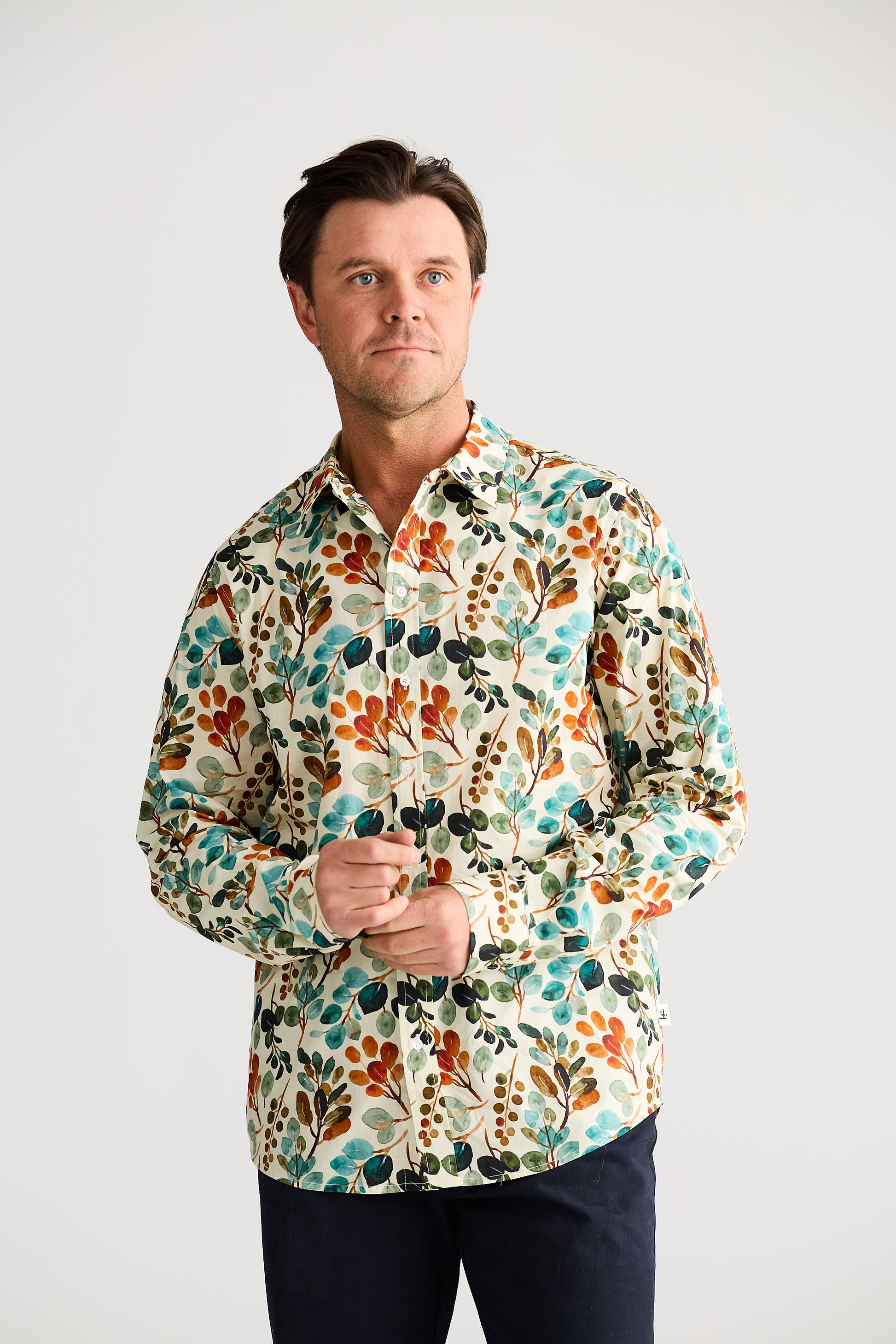 Man wearing a colorful floral shirt against a white background