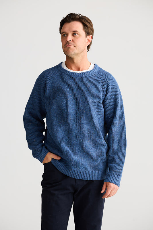 Man wearing a blue sweater against a white background