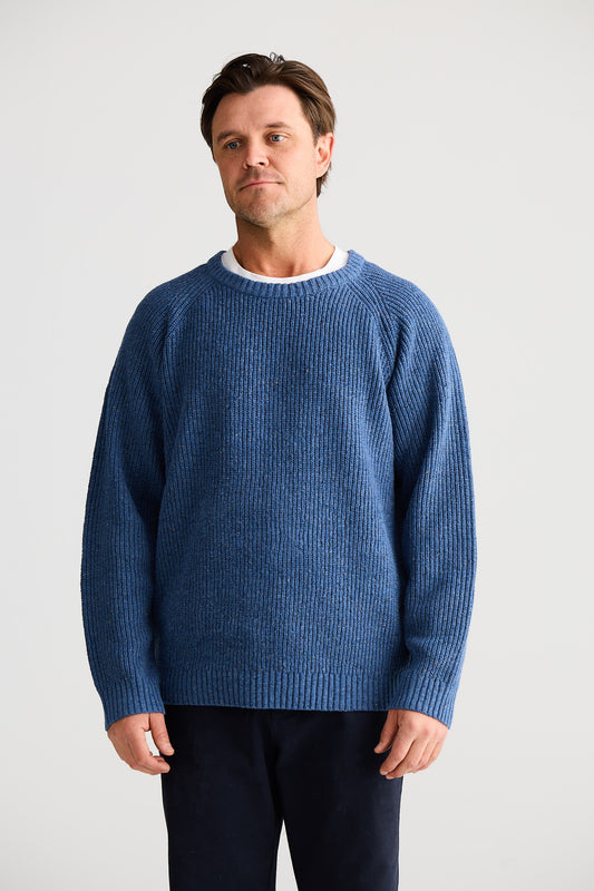 Man wearing a blue sweater against a plain background